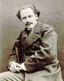 Middle-aged man, receding hair, moustached, looking at camera