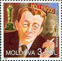 A stamp of an man holding a cigarette. Near him an Academy Award, a woman and some white capital letters are visible.