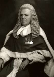 Judge Melford Stevenson in wig and gown, wearing medals