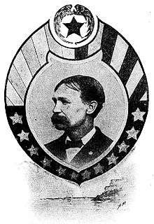 Head of a white man with a bushy mustache wearing a dark suit and bow tie. The portrait is surrounded by an oval-shaped frame decorated with stars and stripes.