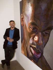 Nahem Shoa standing next to his Giant Head of Ben on display at Hartlepool Art Gallery