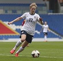 A woman in a white and navy blue football kit