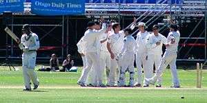 The New Zealand cricket team celebrating a wicket.