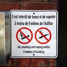 The sign states: No smoking and vaping within 9 meters of building.