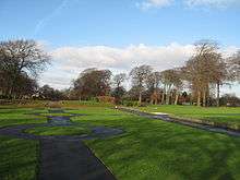 View of formal paths,  green grass and trees in the distance