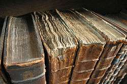 Photograph of a row of ancient books, some with disintegrating leather covers