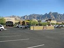 Photo shows Ulta, Tilly's and Best Buy stores at the Oro Valley Marketplace with Pusch Ridge rising in the background.