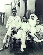 Three men in hospital pyjamas sitting with female nurse
