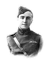 Head-and-shoulders portrait of young man in military uniform with forage cap and pilot's wings above a single ribbon on left breast pocket