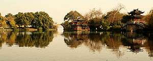 A lake with a bridge and a pagoda on the lakeside.