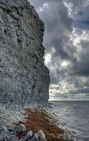 limestone cliffs at the shore with clouds