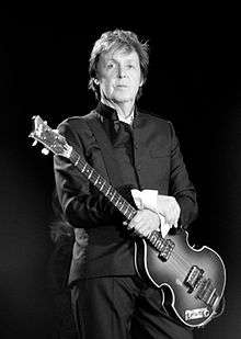 Black and white image of McCartney, holding a guitar, in 2010
