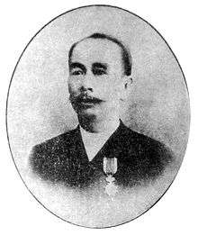 A black and white photograph of a Chinese man in a suit, looking forward