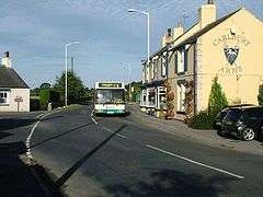 Carlbury Arms pub on road through Carlbury with bus