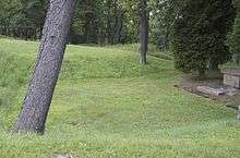 A patch of mowed grass that is indented into the ground.