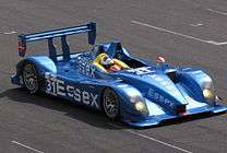 A view of a bright blue race car with the word Essex clear to read on the side