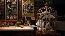 Film screenshot of a rabbit in a cage desperately reaching for a carrot sitting on a nearby table. The table has various jars on it, and posters for the magic show can be seen on the wall in the background.