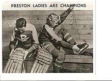 two women putting on hockey equipment