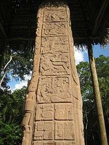 The side of a stela, divided into square panels containing sculpted hieroglyphs