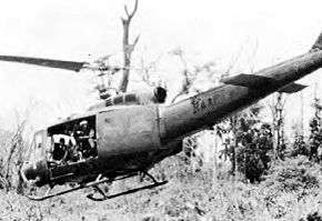 Black and white photograph of a helicopter flying at a low altitude