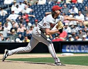 photo of major league baseball pitcher Randy Johnson on the mound, right after releasing a pitch to the plate, arm extended in front of him.