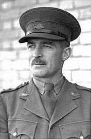 Head-and-shoulders portrait of moustachioed man in military uniform with peaked cap
