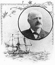 Head of a balding white man with a mustache, wearing a dark suit coat and bow tie. The portrait is surrounded by a decorative frame and a drawing of a sailing ship at sea.