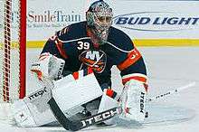 Rick DiPietro in full goalie uniform and equipment, on the ice and defending his goal with his stick out in front of him