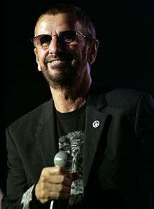 A colour photograph of Starr wearing sunglasses and a black T-shirt.