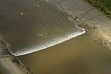 A tidal bore wave moves along the River Ribble between the entrance to the river Douglas and Preston.