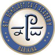 A blue school logo with the word "St. Scholastica's Academy,Marikina" written in gold lowercase letters and side of the circle.