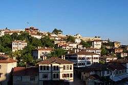 White houses with red tile roofs on a hillside.