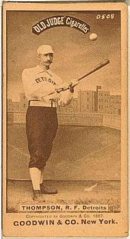 A sepia-toned baseball card image of a man wearing an old-style white baseball uniform and cap
