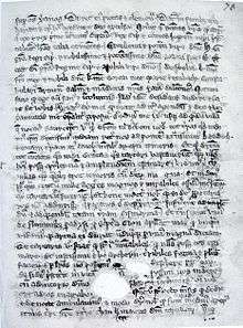 A single page from a 14th-century manuscript. Un-illustrated, it is covered with dozens of lines of Latin text. The parchment is aged and has some holes in it towards the bottom, which evidently existed before the text was written around them.