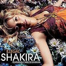 An image showing Shakira laying on flowers looking directly into the camera