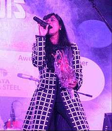 Shilpa Rao singing a song with a bouquet