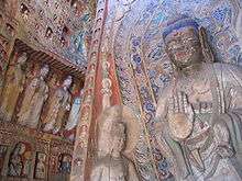 Buddhist deities of various sizes carved from rock and painted in many colors.