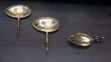 three spoons, two with holes, one with a curved short handle