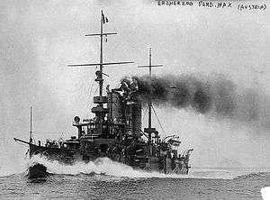 A small grey battleship traveling at full speed with smoke coming out of its two round funnels.