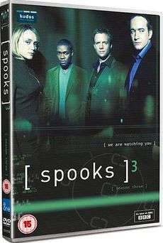 A DVD boxset cover in a dark green background with the logo "[ spooks ]3. At the top half there are four people standing. From left to right, a short blonde-haired woman, a black British man, and two Caucasian males wearing a shirt and jacket.