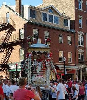 A life size statue of St. Agrippina di Mineo in an ornate canopy accompanied by the North End Marching Band.