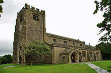 A stone church with a clerestory and a broad battlemented tower