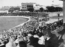 A crowd watching a cricket match
