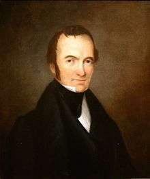 Portrait of a man with receding hairline and long sideburns, wearing an 1840s-style suit.