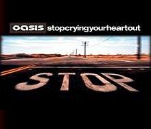 Picture of a desertic road. In the pavement the word "Stop" is painted in capital white letters. Above it, Oasis's stylised logo and "Stop Crying Your Heart Out", written in lowercase white letters and without spaces, appear.