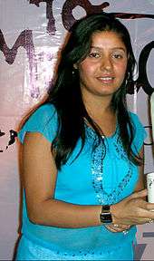 Sunidhi Chauhan smiling wearing a blue top