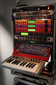Several rack-mounted synthesizers that share a single controller