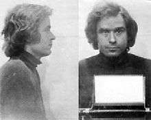 Bundy is facing right in the first photo and facing front in the second. He has medium long hair and is wearing a turtleneck sweater.