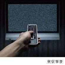 An arm points a remote at a TV displaying static.
