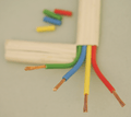 White-coated cable, cut away to show green, blue, yellow and red coated wires